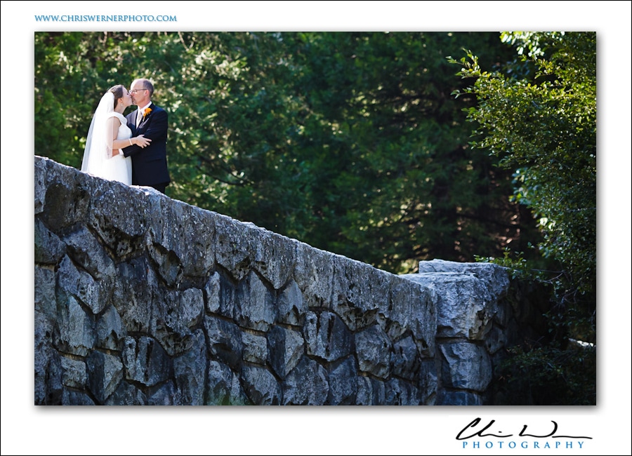 Bride and groom kissing on Sentinel Bridge, Yosemite Wedding Photographers.