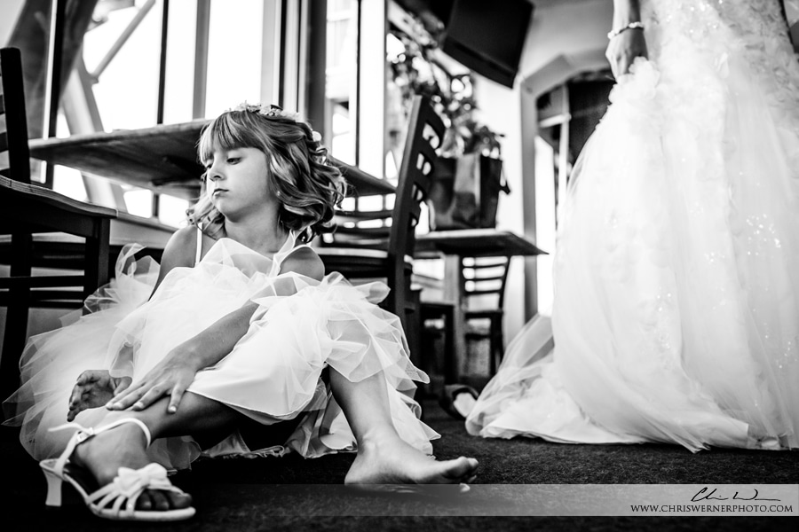 Squaw Valley PlumpJack wedding photos of a flower girl putting on her shoes before the wedding at High Camp.