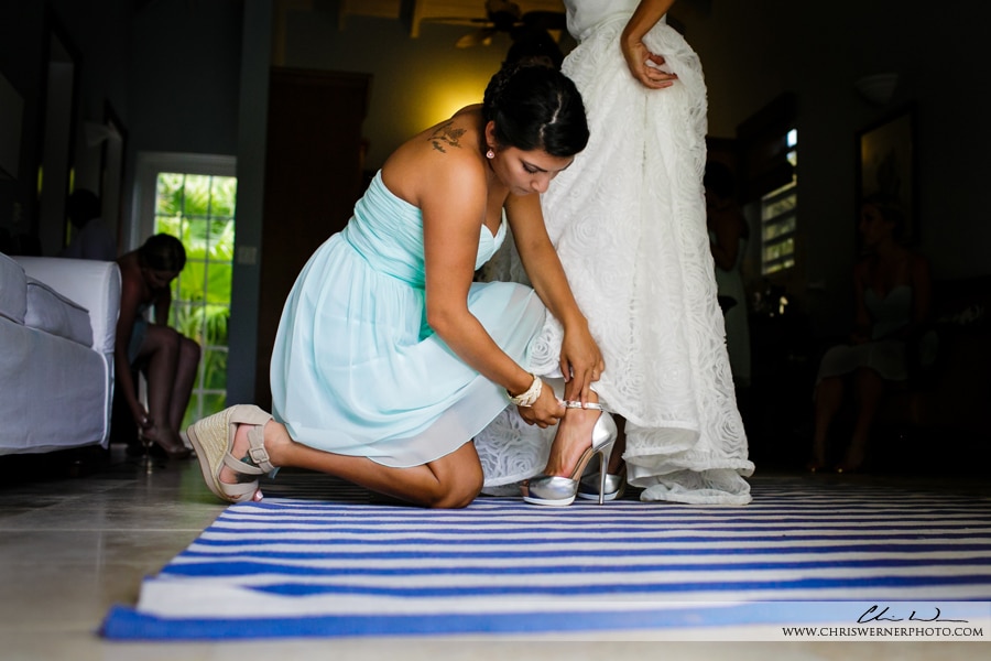 Anguilla wedding photos of the maid of honor putting on the bride's shoes. 