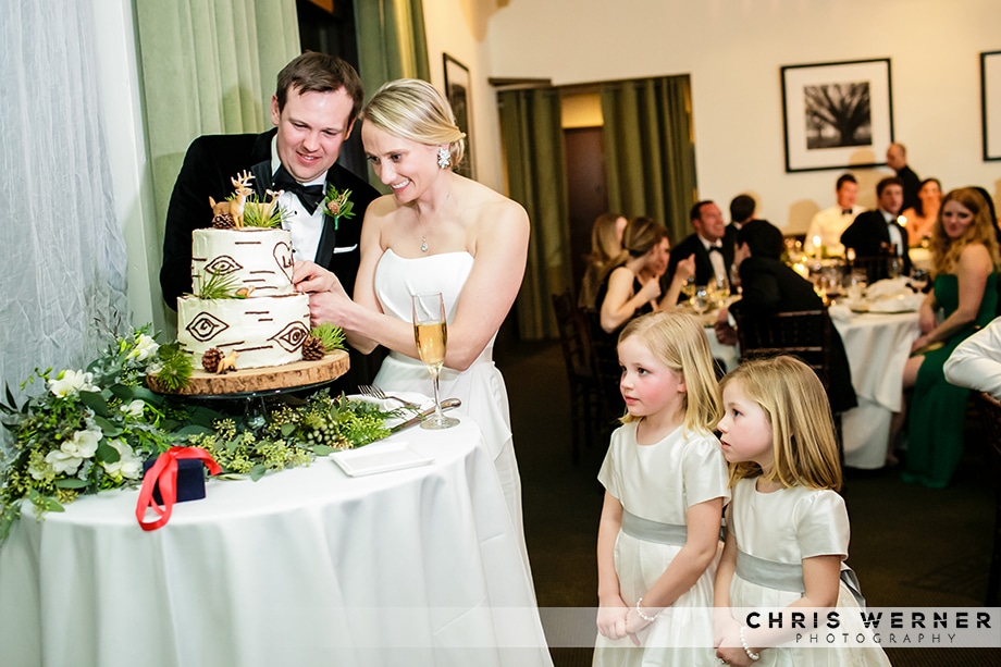 Bride and groom cutting the cake at a Squaw Valley winter wedding while flower girls watch.