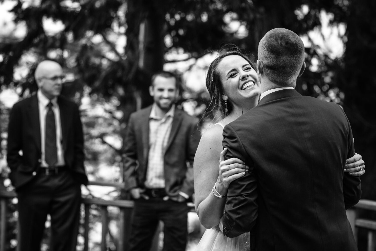 A joyful couple during their first dance at a backyard wedding reception.