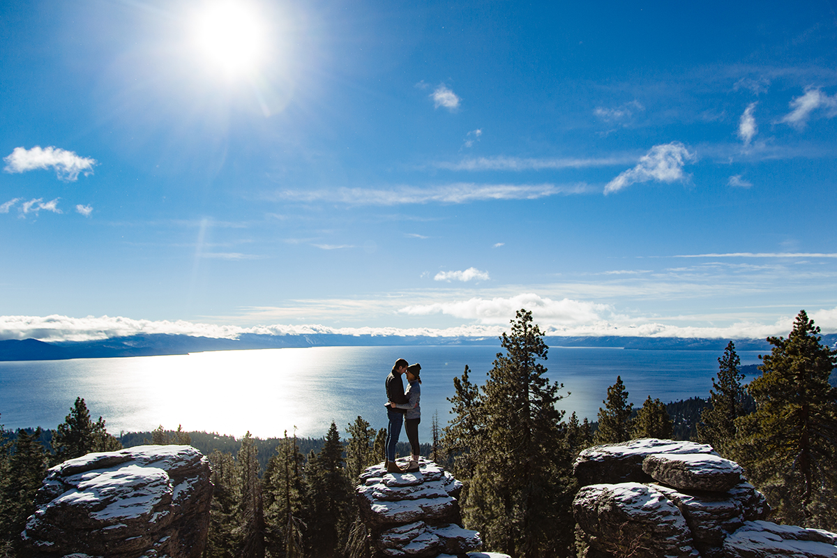 A couple who decided to get engaged in Lake Tahoe enjoy a solitary mountaintop overlooking the water.