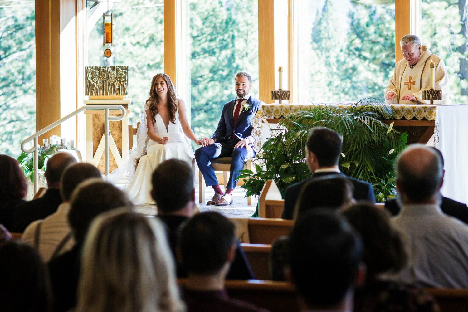 A bride and groom sit together at the altar during their Catholic wedding ceremony in Lake Tahoe.