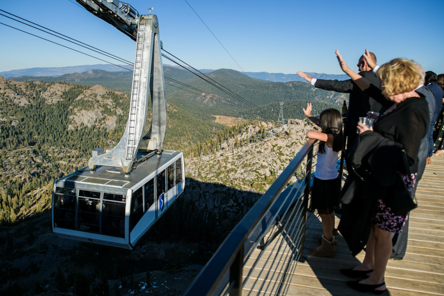 Guests wave at the Palisades Tahoe Aerial Tram during a High Camp wedding reception.