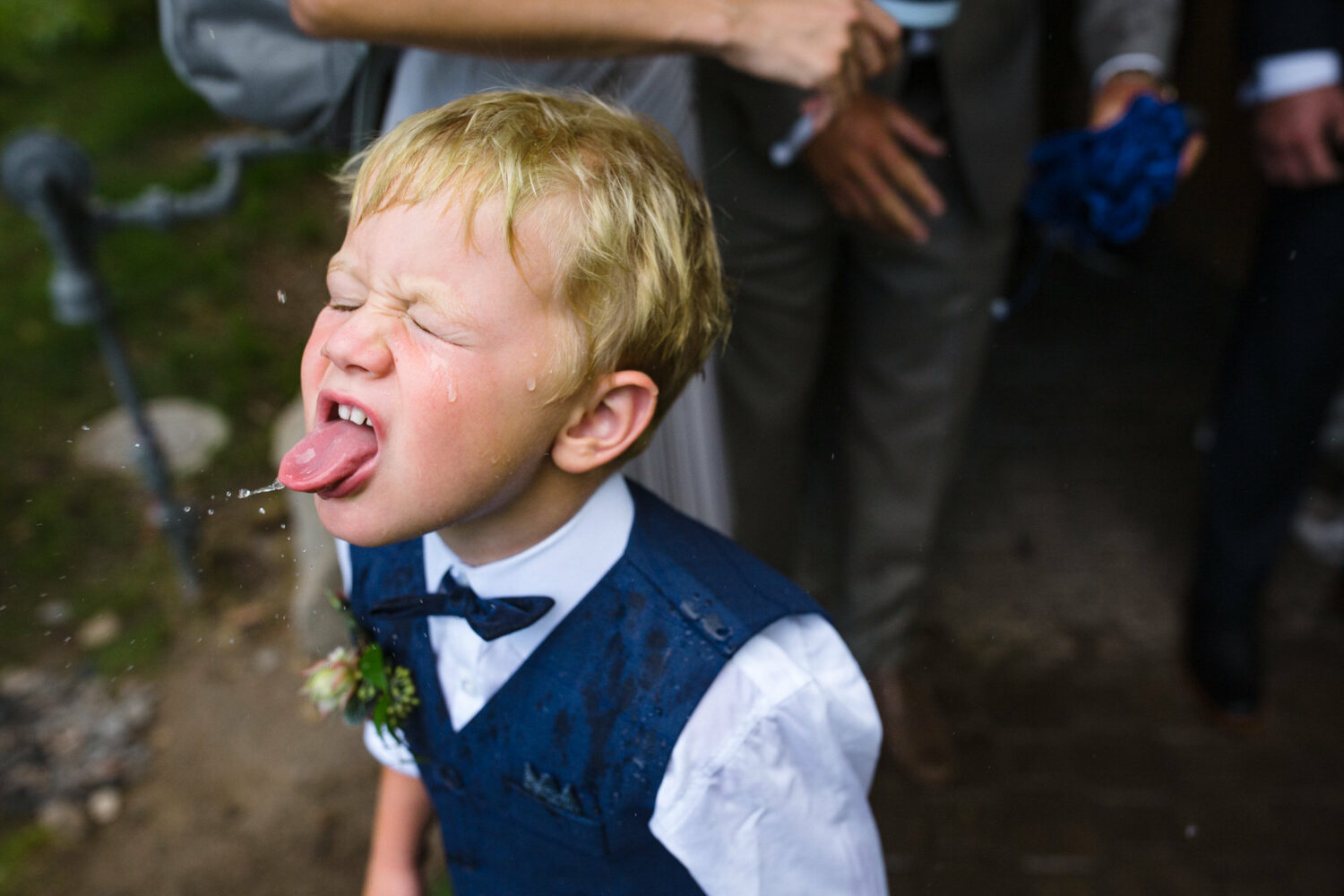 A boy ring bearer catches raindrops with his tongue at a Carnelian Bay wedding.
