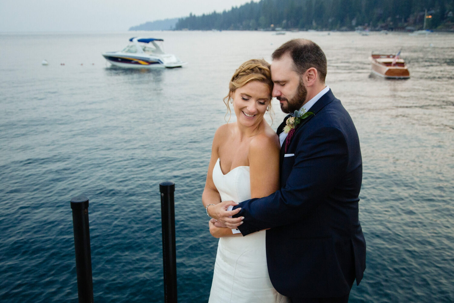 A bride and groom enjoy a romantic moment next to Lake Tahoe at their Gar Woods wedding.