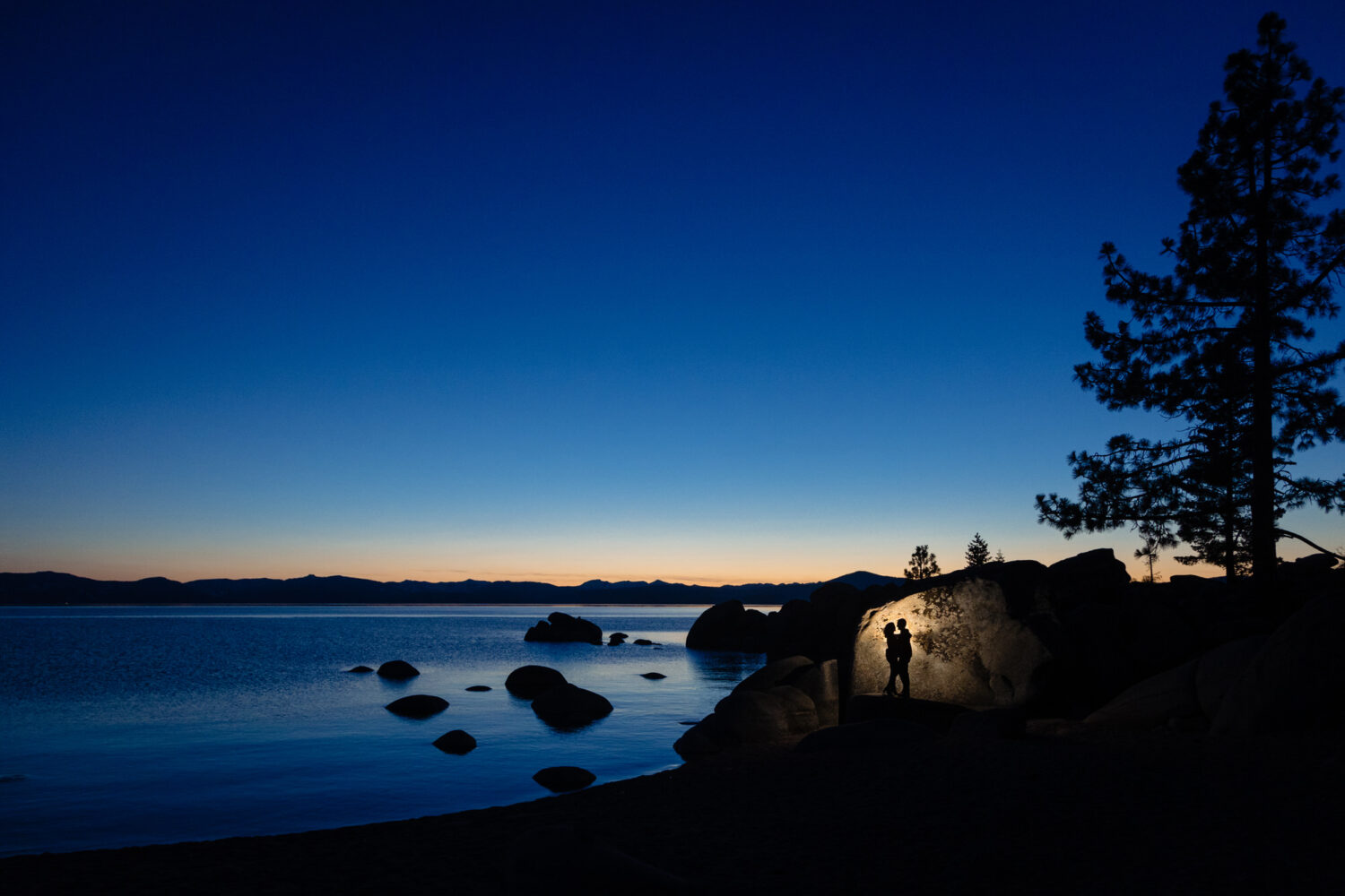 Artistic silhouette of a couple at dusk in front of Lake Tahoe.