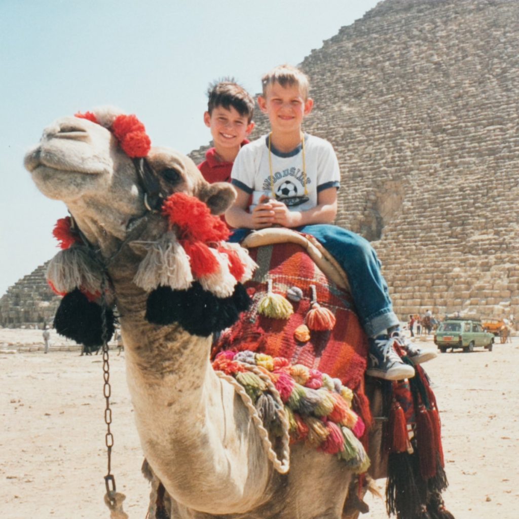 Chris Werner as a young boy, riding a camel in front of a pyramid in Egypt.