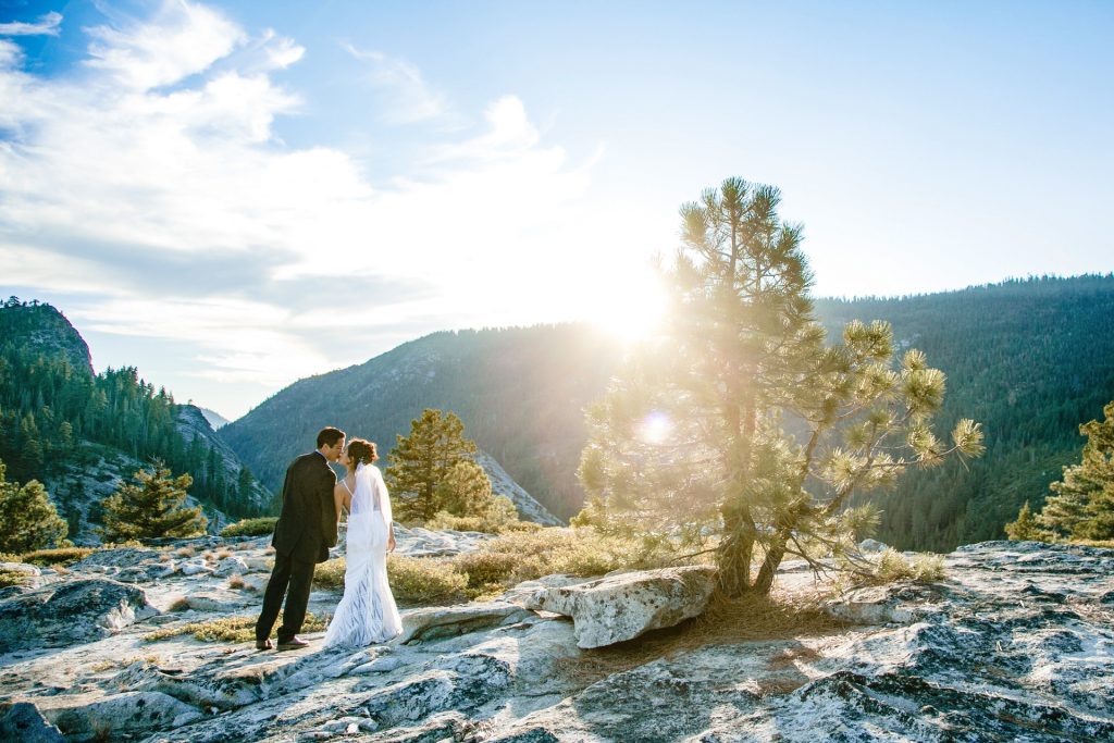 A couple that decided to elope on a mountain in Lake Tahoe share a sunset kiss.