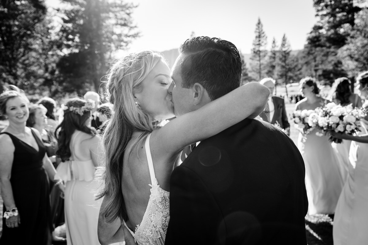 Bride and groom share a romantic kiss at their outdoor forest wedding.