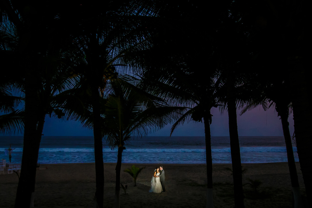 A bride and groom enjoy sunset on the beach in Zihuatenejo.