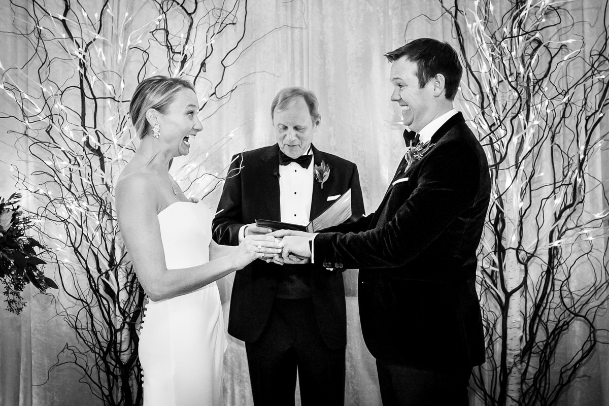 A bride and groom look at each other with excitement at their indoor winter wedding.