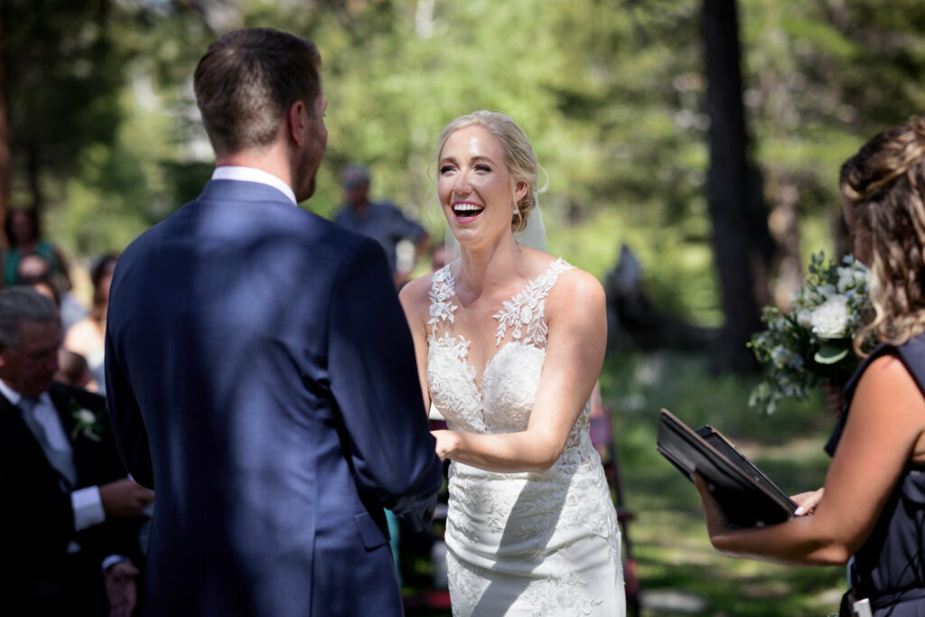 Bride and groom laughing while exchanging vows during the wedding ceremony.