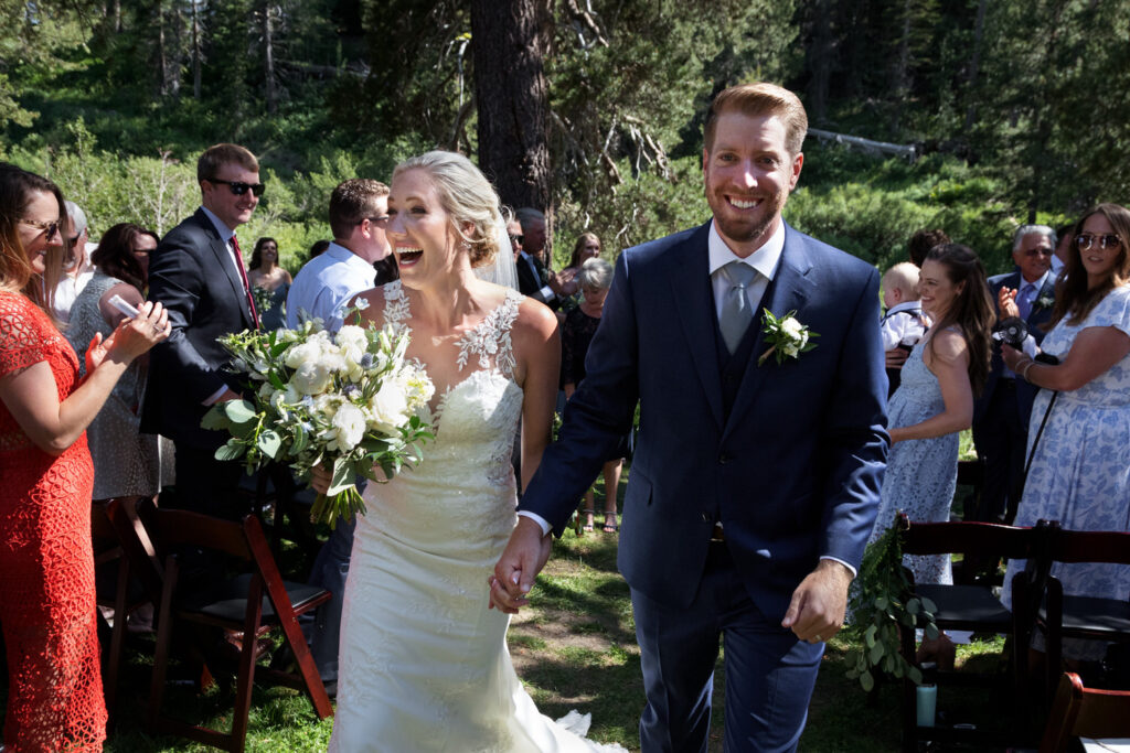 A happy bride and groom exit their wedding ceremony at Dancing Pines Resort in Truckee, California.