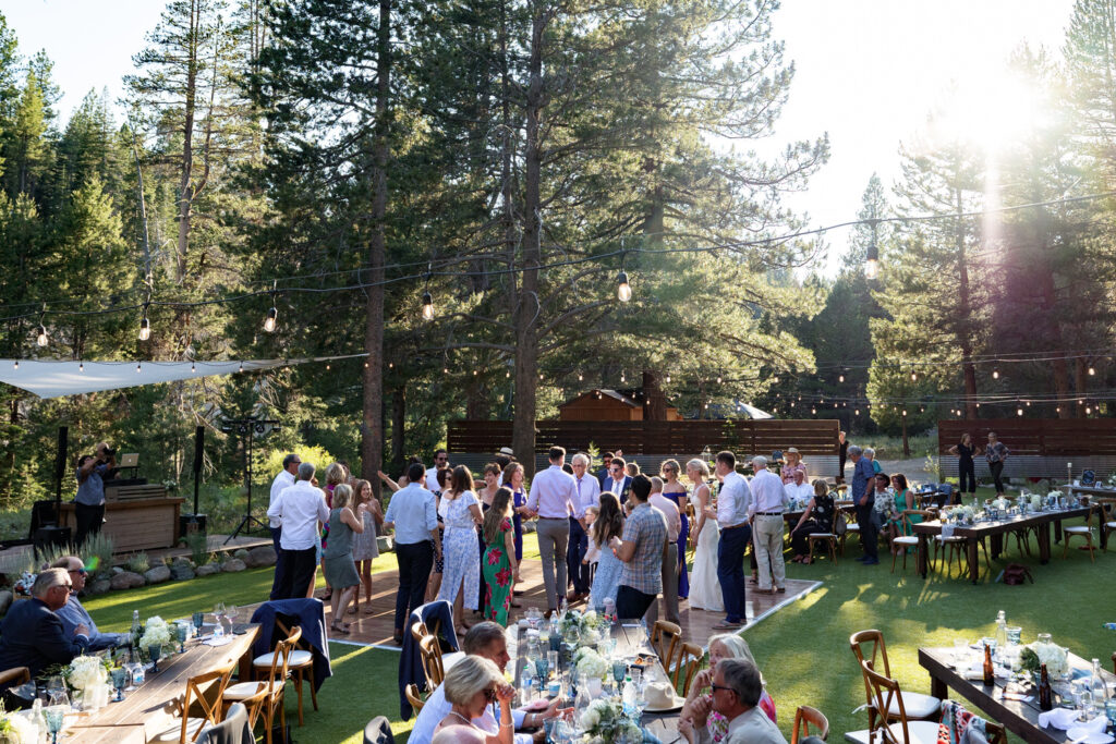 A wide-angle view of the reception area at Dancing Pines as wedding guests enjoy a warm summer evening.