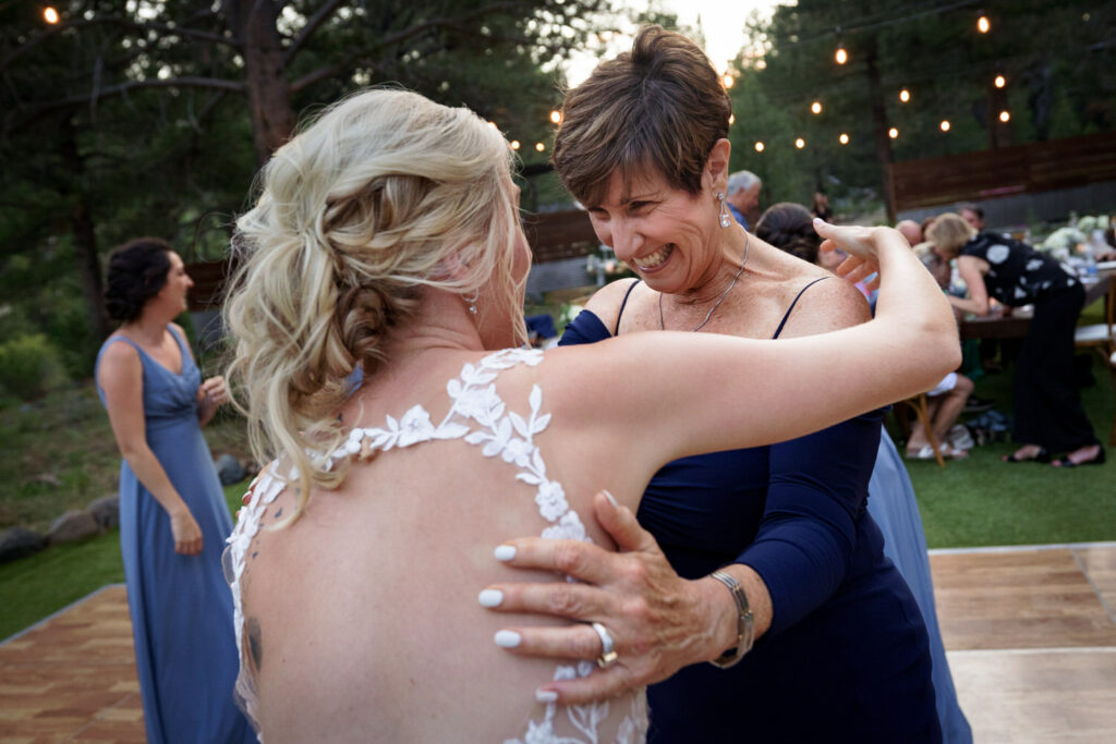 The mother of the bride joins her daughter on the dance floor as they celebrate their outdoor Dancing Pines wedding.