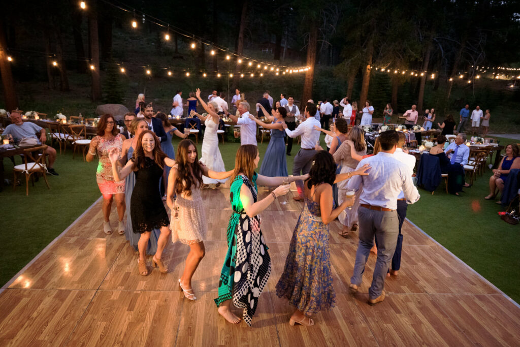 The wedding party forms a conga line on the dance floor at Dancing Pines, a wedding venue near Lake Tahoe, CA.