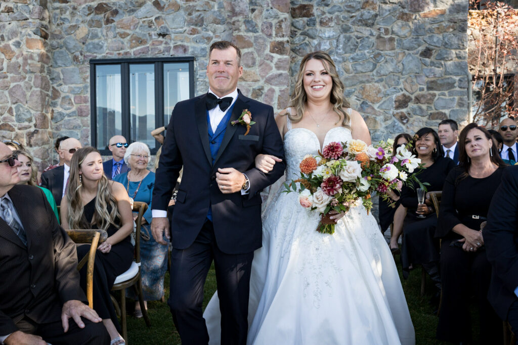 The bride and her father walk down the aisle at a Thunderbird Lodge wedding ceremony.