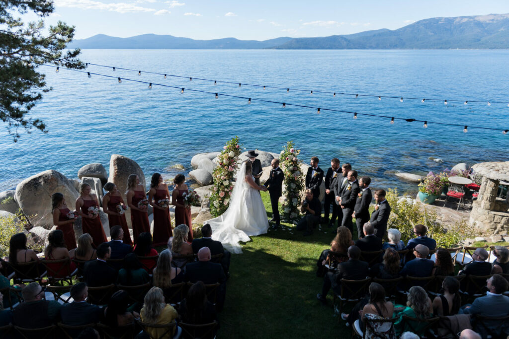 A wide-angle view of a lakeside wedding ceremony at Thunderbird Lodge next to Lake Tahoe.