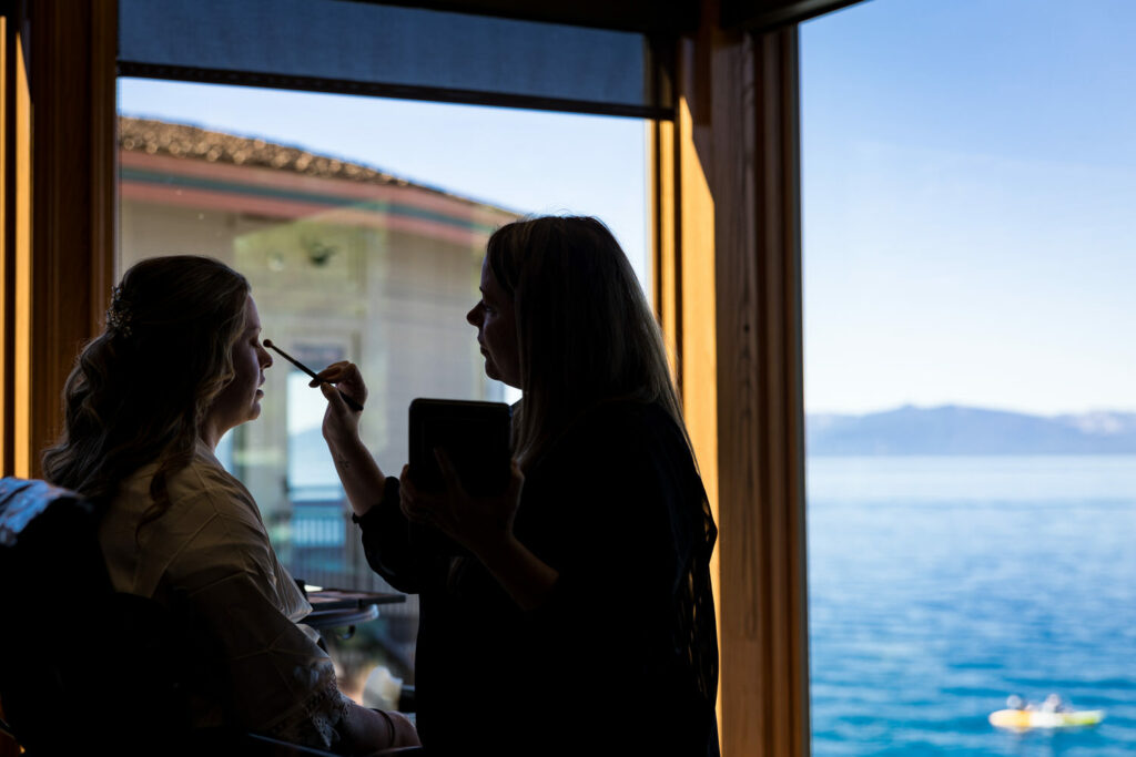 Silhouette photo of bridal preparations in a room at the Thunderbird Lodge overlooking Lake Tahoe.