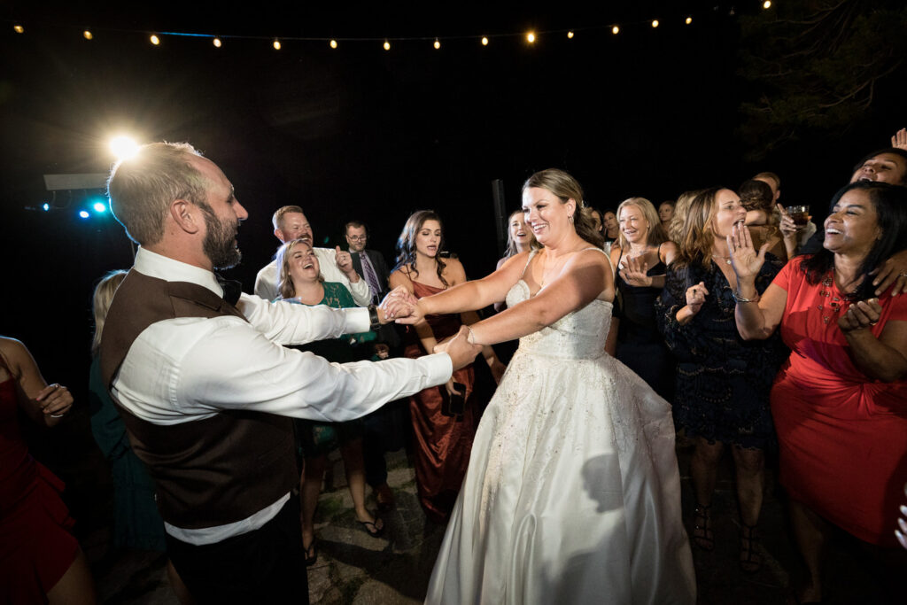 The wedding party celebrates on the dance floor with the bride and groom at the end of a Thunderbird Lodge wedding reception.
