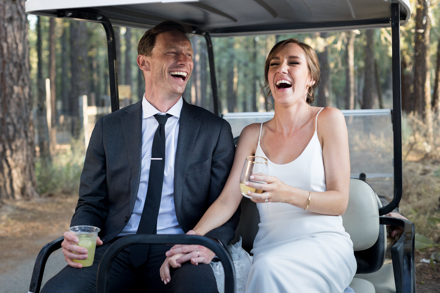 The bride and groom ride in a golf cart for their sunset photos at Chalet View Lodge.