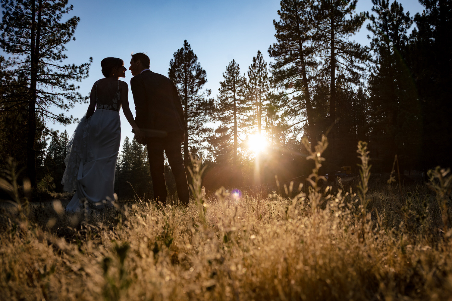 A silhouetted bride and groom lean together for sunset photos at Chalet View Lodge.