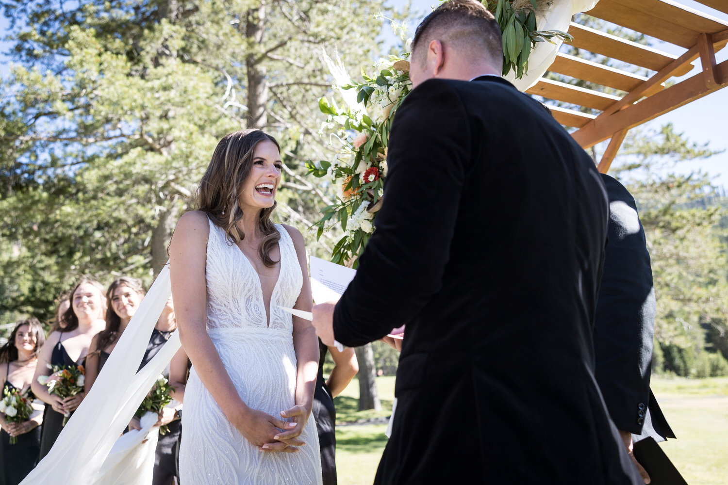 A joyful exchange of vows under a simple wooden arch at an Everline Resort wedding.