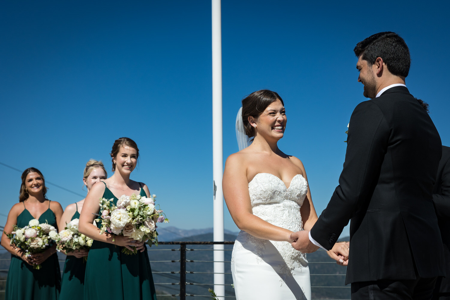 A joyful bride smiles at her groom during a summer wedding at Palisades Tahoe.