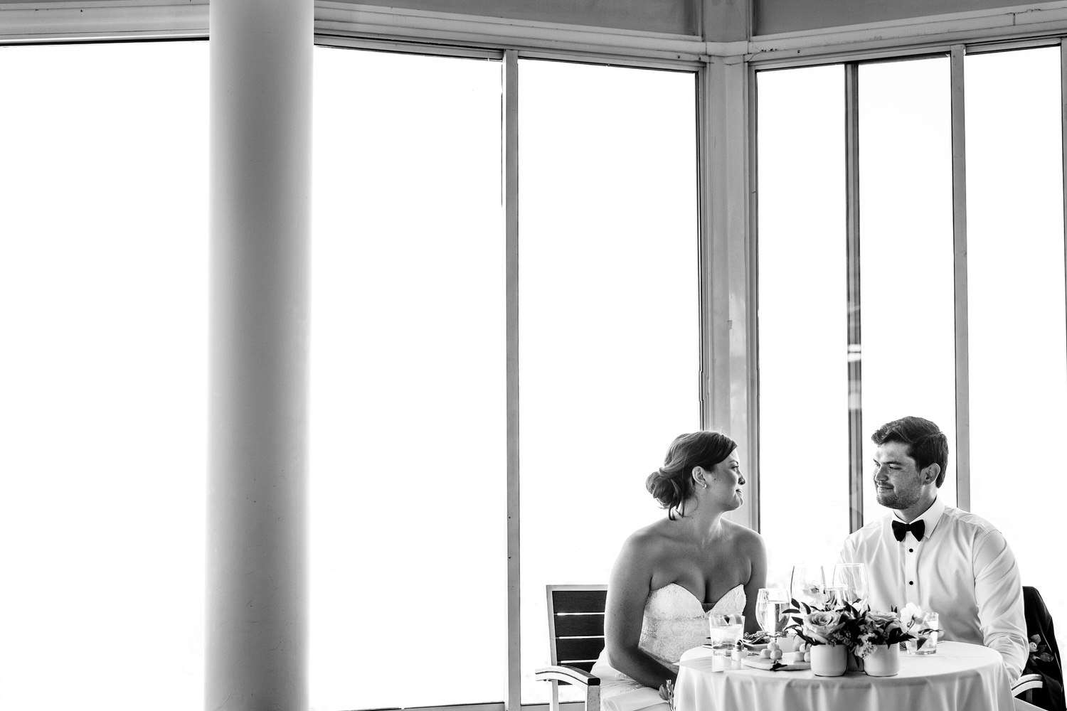 A sweet candid moment between the bride and groom at dinnertime, captured by Lake Tahoe wedding photographer Chris Werner.
