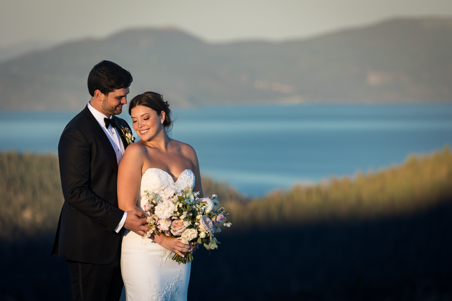 Sunset portrait of a bride and groom with Lake Tahoe in the background.