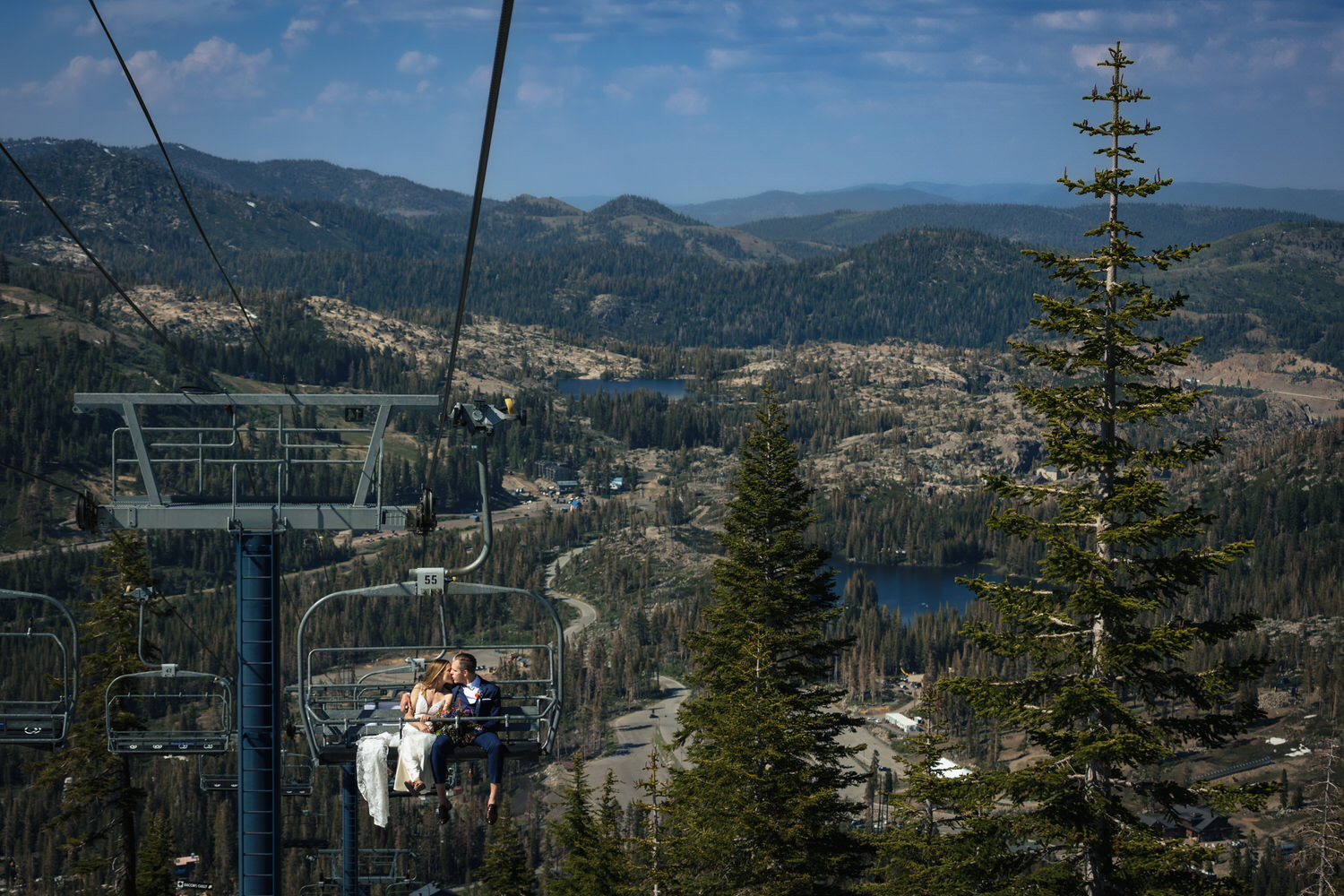 A wide angle view of a bride and groom riding the chairlift to their Mt. Disney cocktail hour.