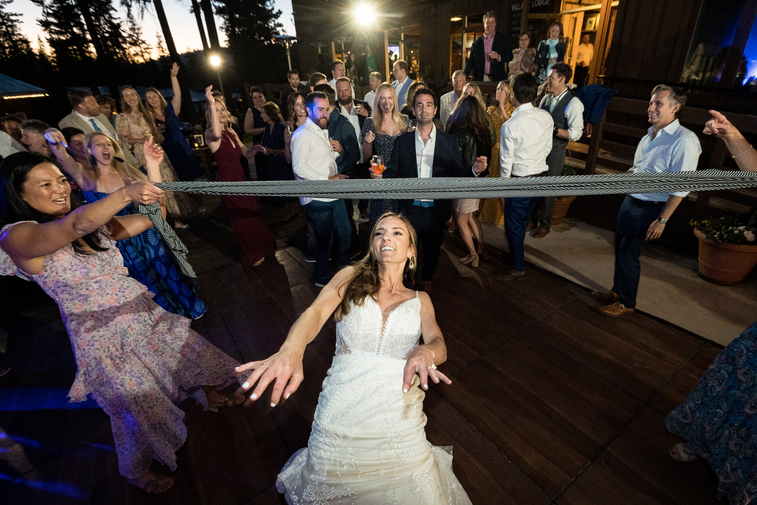 Wedding guests create a fun wedding game for the dance floor- limbo using a long scarf!