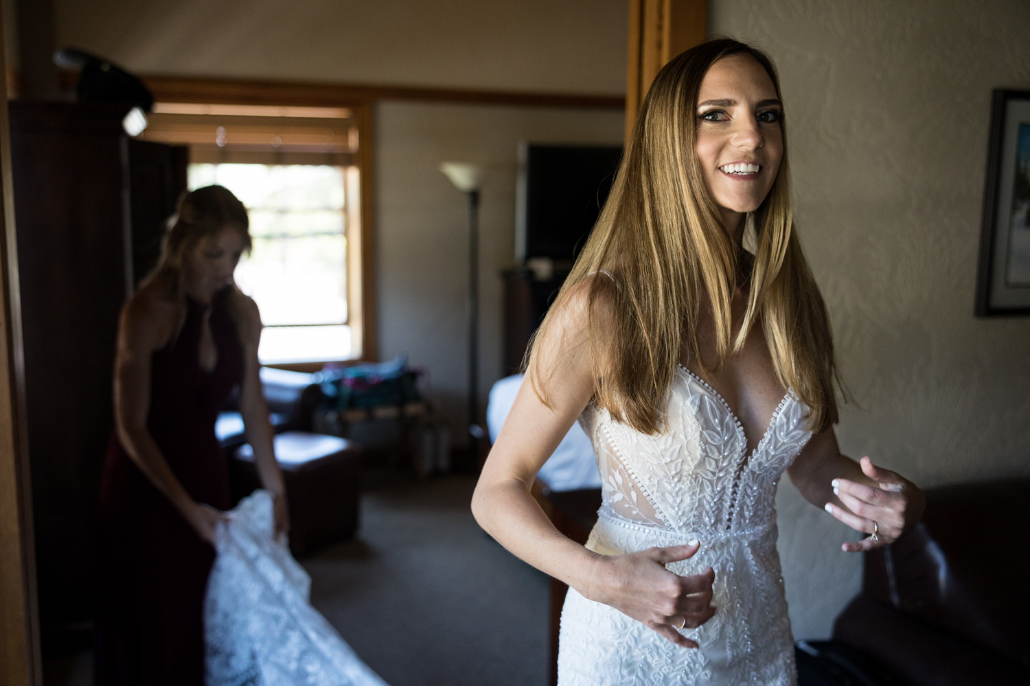 An excited bride in her wedding dress in the Sugar Bowl Lodge bridal suite.