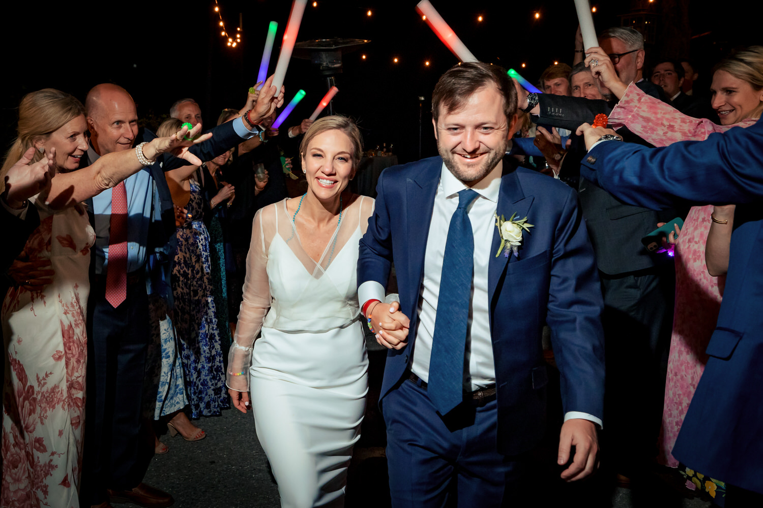 LED foam party sticks frame a couple's exit from their wedding reception.