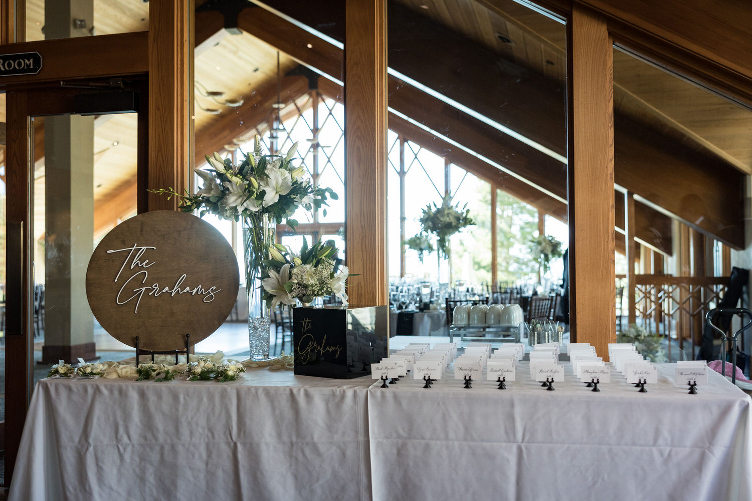 Wedding reception welcome table idea with name cards and a white floral arrangement.