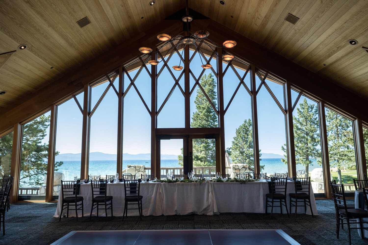 Wide angle view of Lake Tahoe through the floor-to-ceiling windows in the North Room at Edgewood Resort.