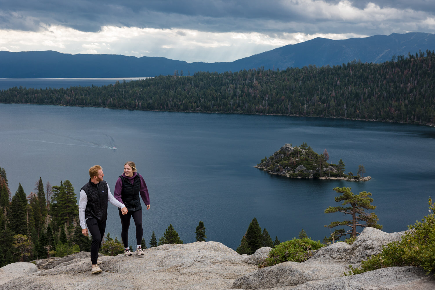 Candid engagement portrait of an outdoorsy couple in front of Fannette Island in Emerald Bay.