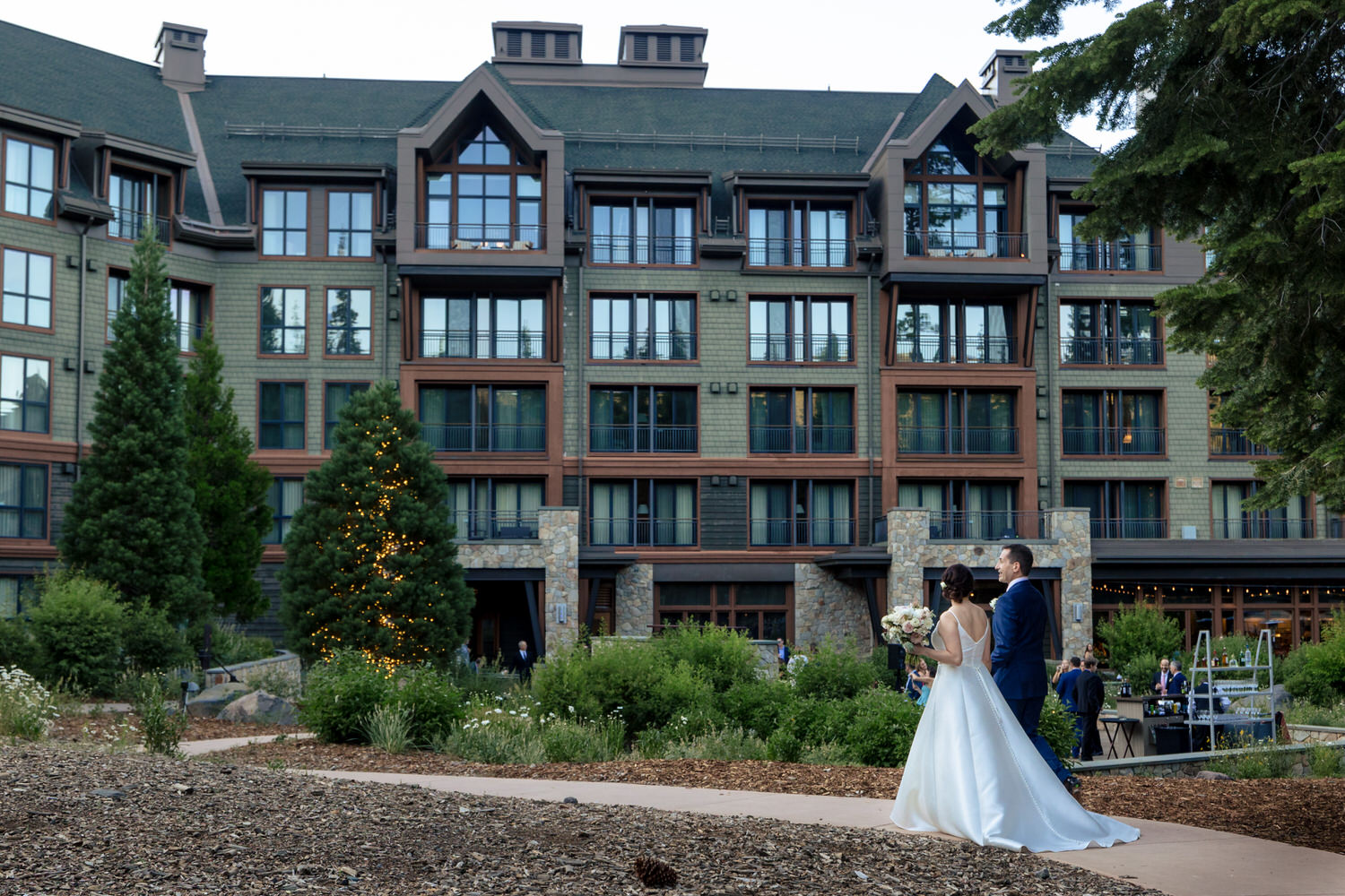 The bride and groom walk to the Fireside Terrace, an outdoor cocktail hour location.