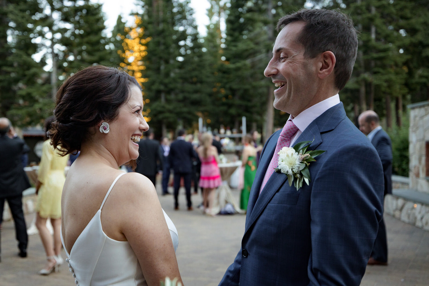 A candid moment shared between a bride and groom during a wedding by the Fireside Terrace. 