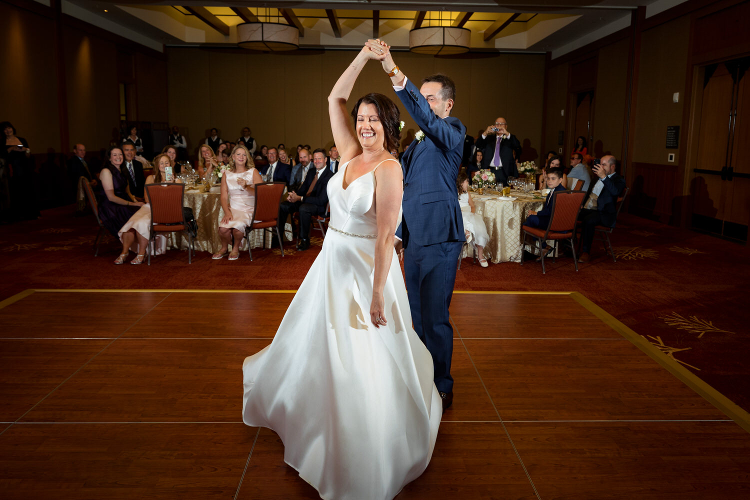 The bride and groom enjoy their first dance at a reception in the Ritz Carlton Ballroom.