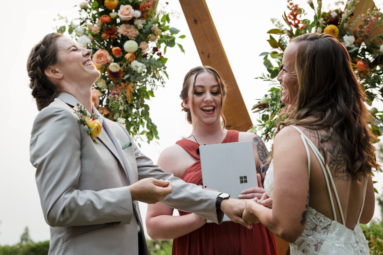 Two brides exchange wedding rings at their LGBTQ backyard wedding.