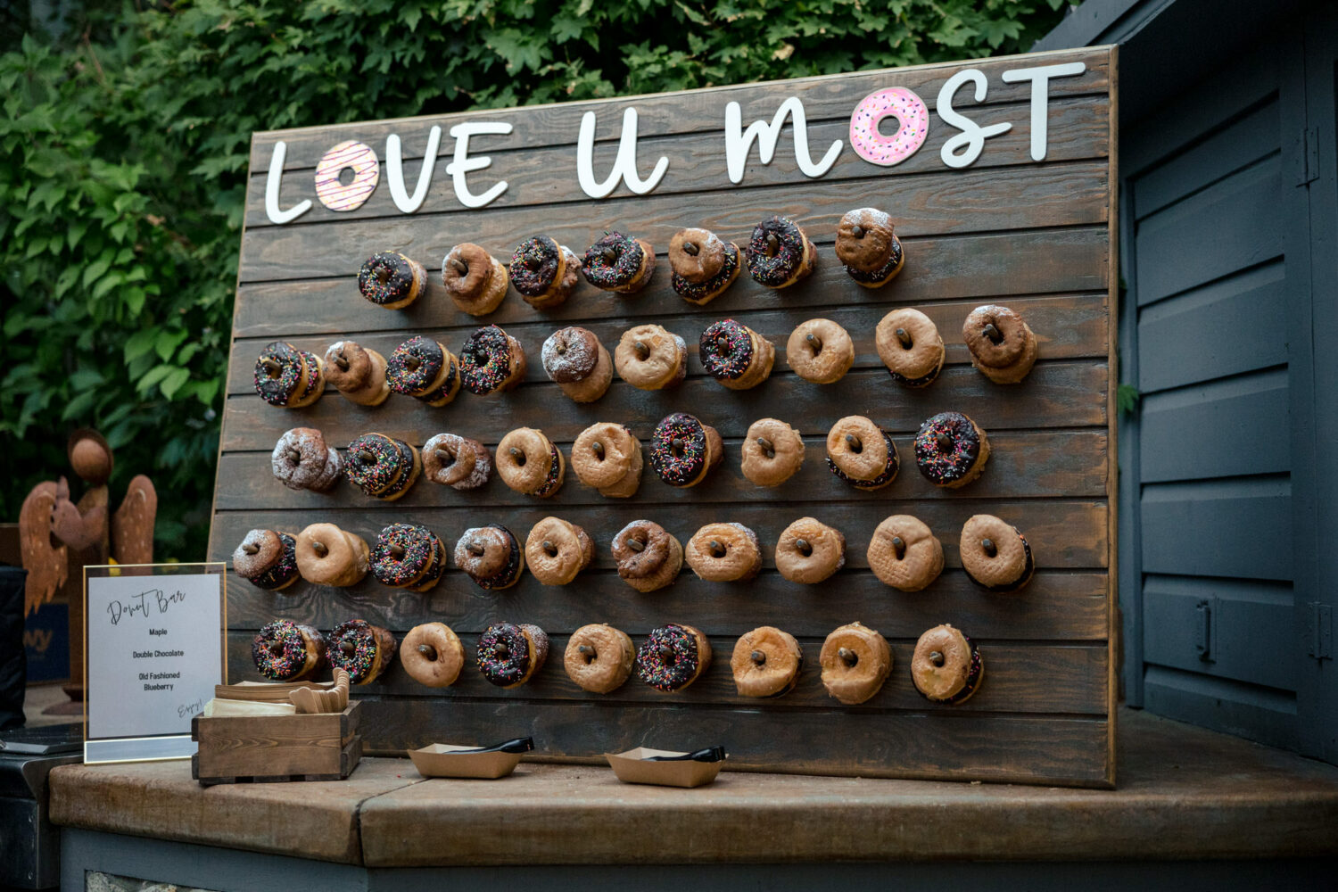 Donut bar with maple, double chocolate, and old-fashioned blueberry donuts on pegs.