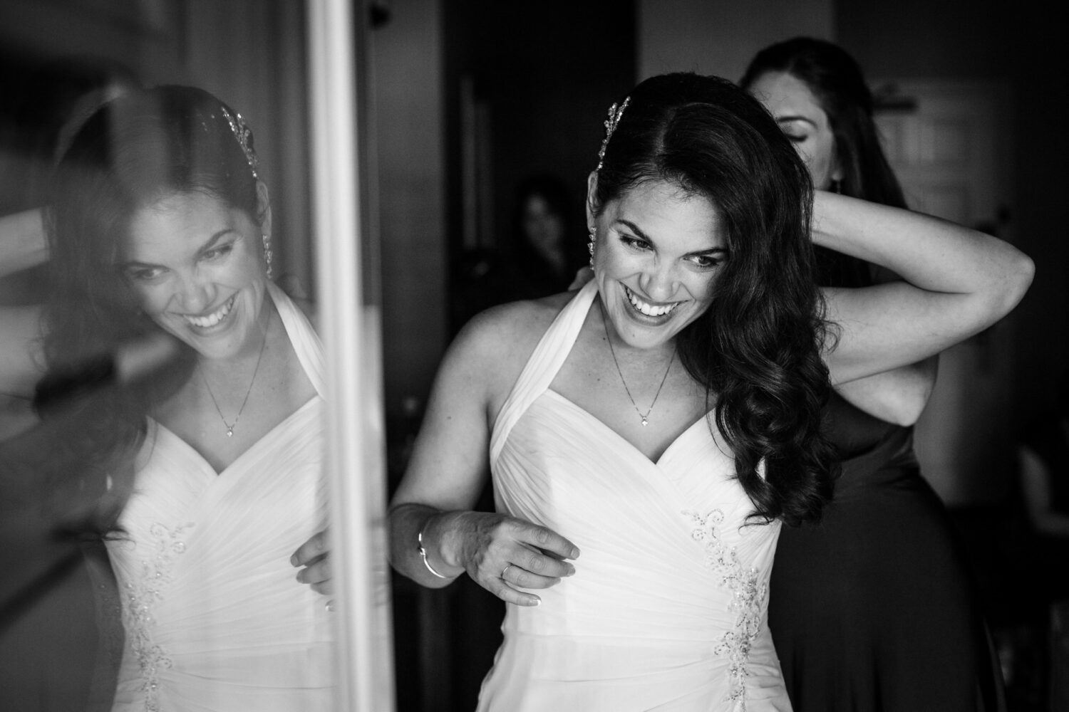A glass door reflects a bride getting ready at the Lakeside Cottages.