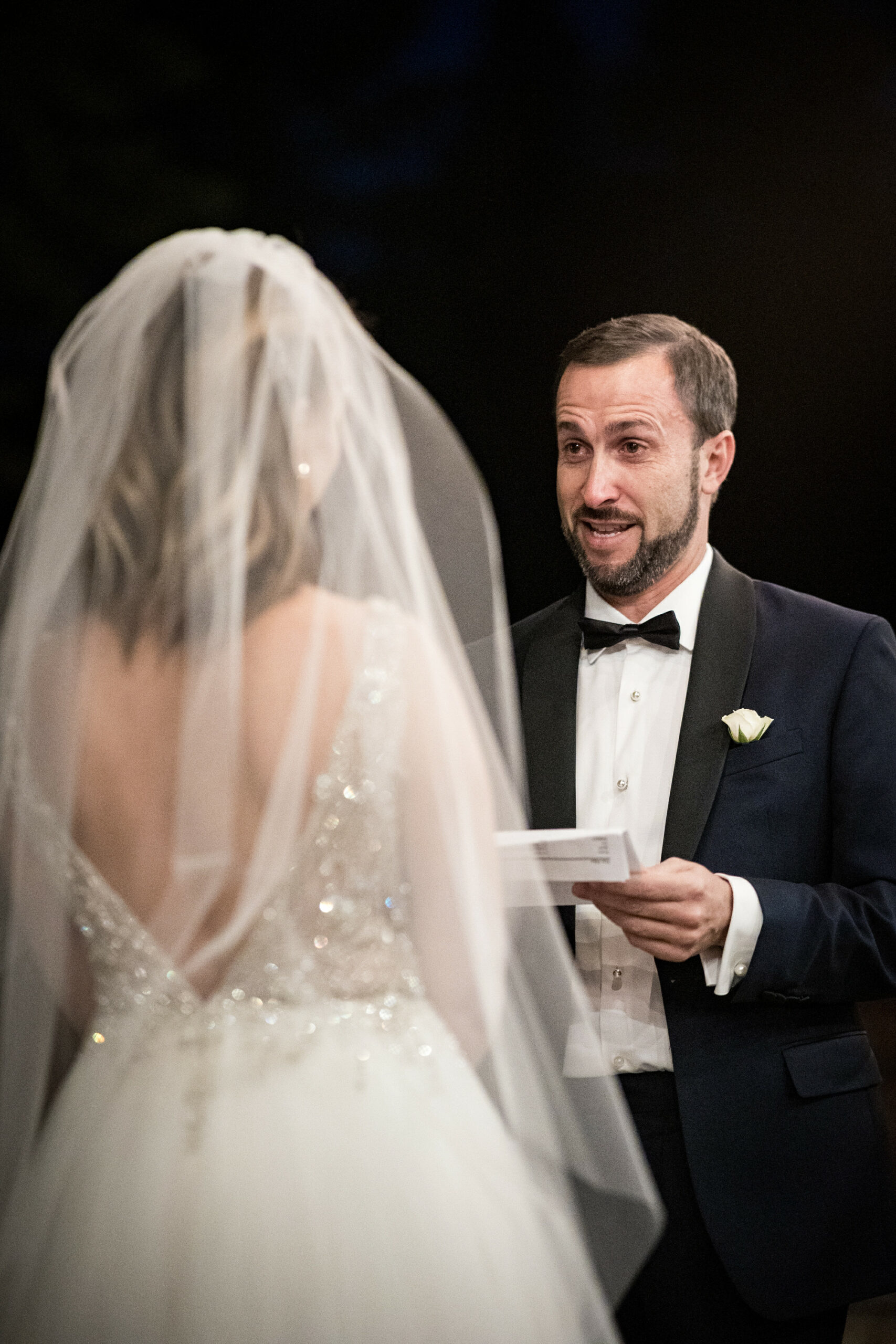 Groom reading his vows at a night wedding.