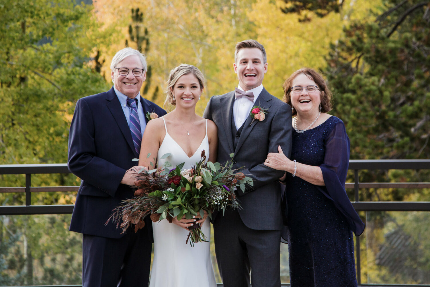 Bride and groom with their parents at a fall wedding in Lake Tahoe with yellow leaves in the background.