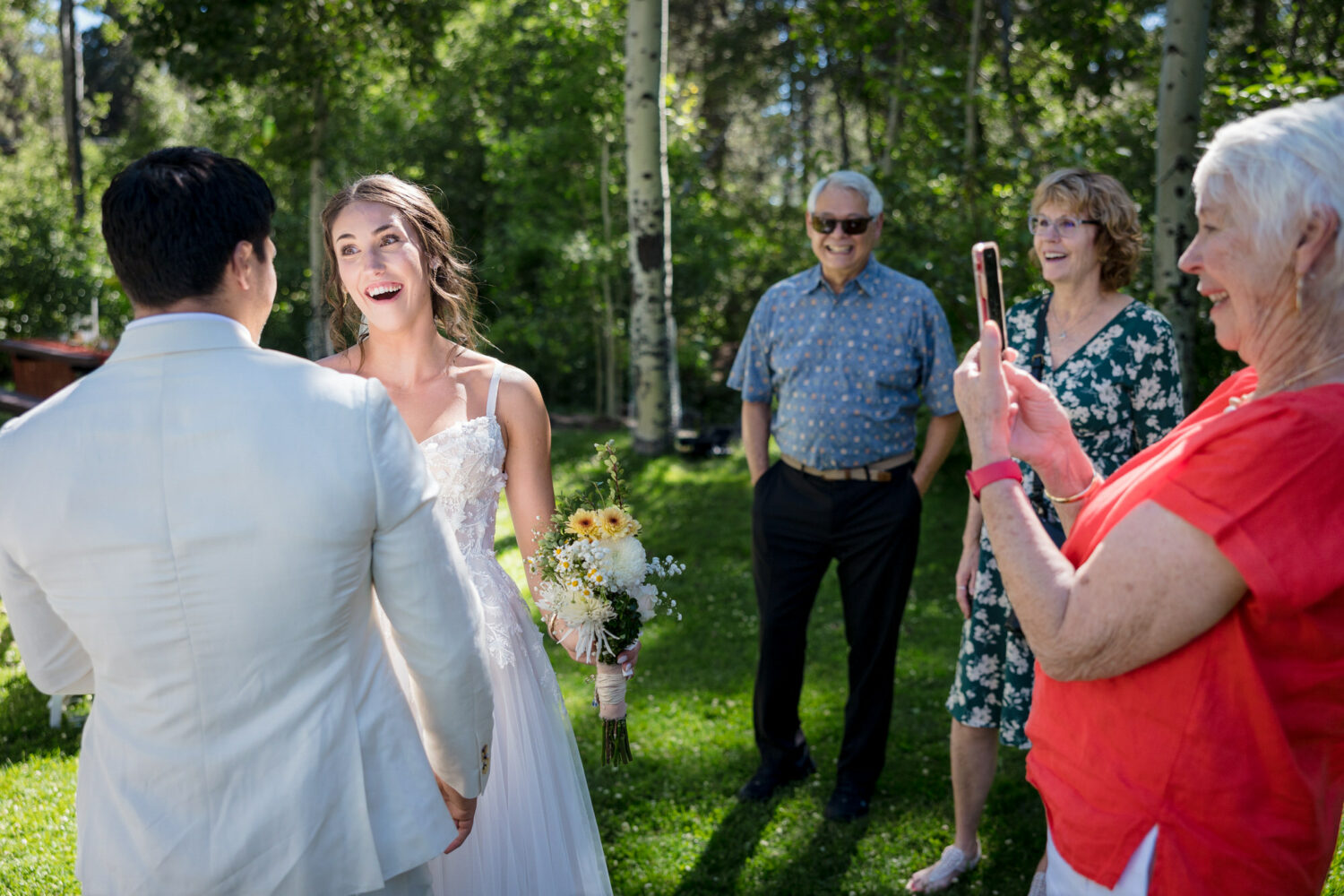 Joy and excitement on a bride's face at an outdoor Lake Tahoe wedding among aspen trees.