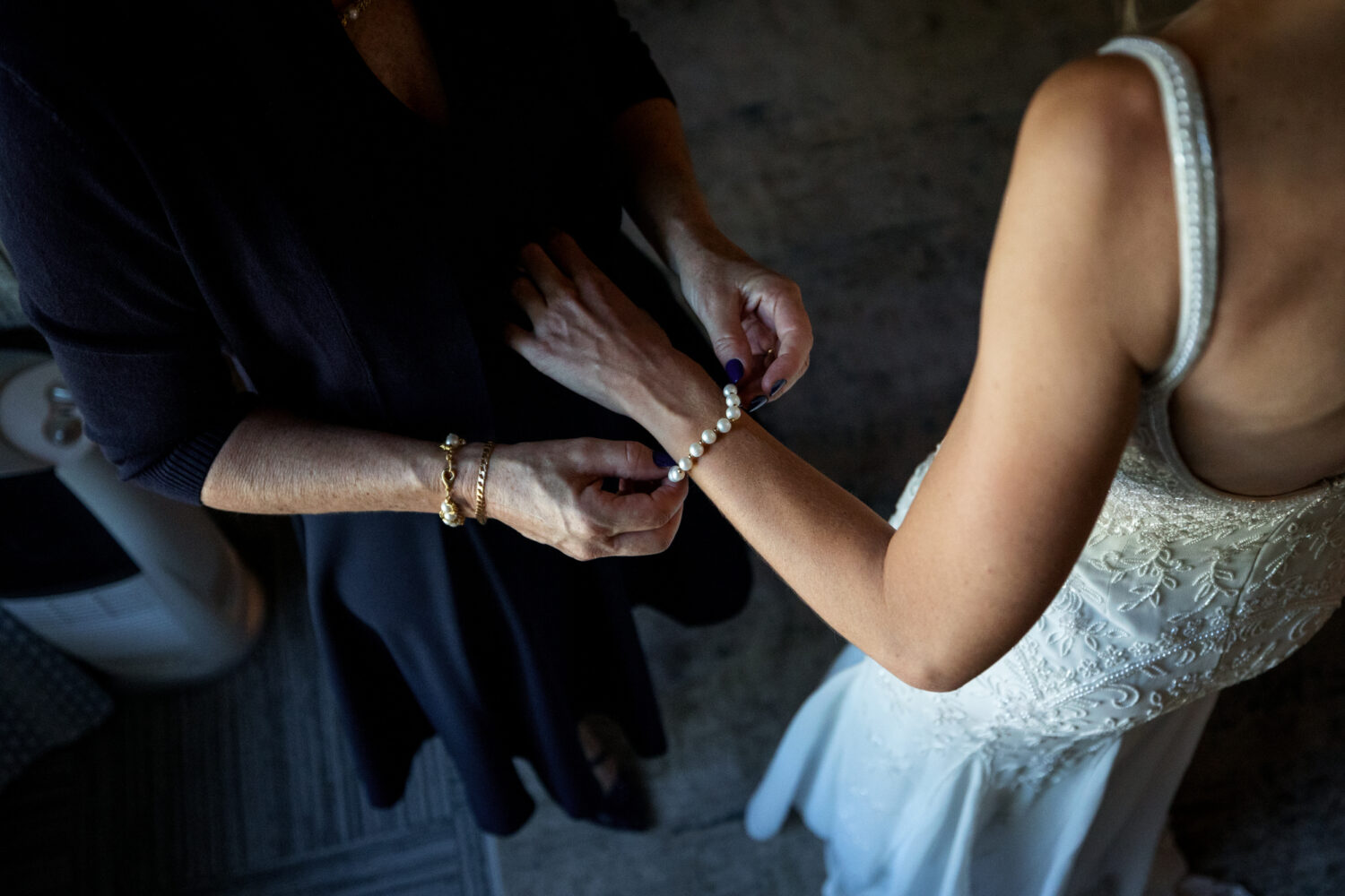 Helping the bride with a bracelet of large pearls.