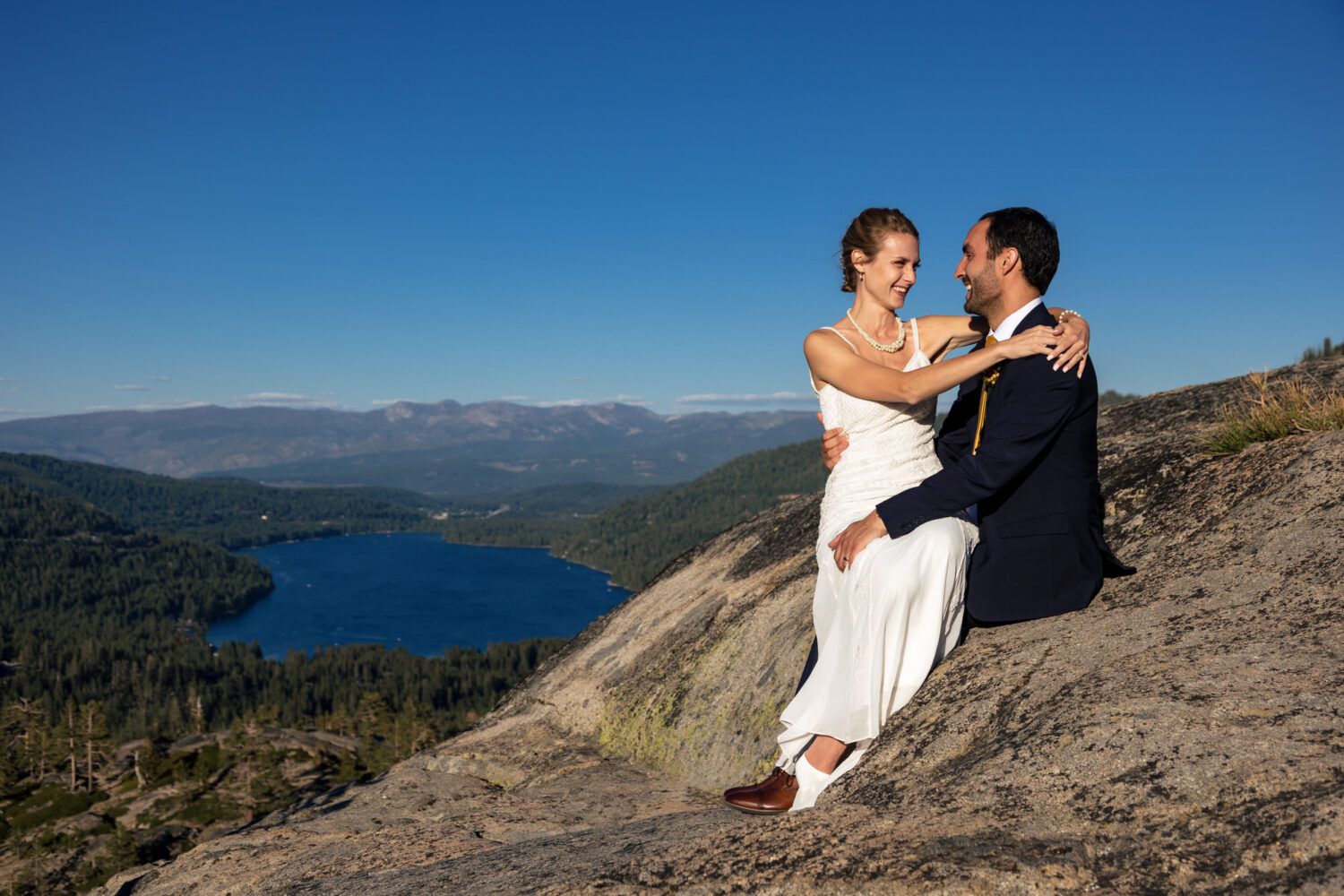 Bride seated in the groom's lap during their Donner Summit wedding photos.