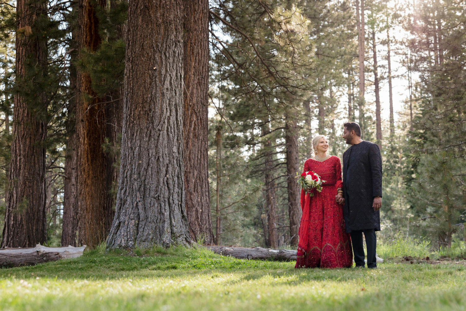A couple that decided to get married at Valhalla Tahoe enjoys a peaceful sunset moment among the pine trees. 